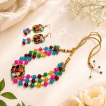 Flat lay view of multicolor bead necklace set with matching earrings and adjustable dori