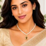 Woman wearing pearl pendant necklace set with champagne stone pendant and matching earrings