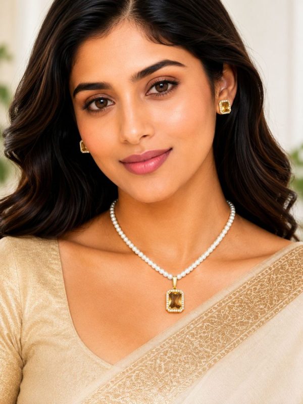 Woman wearing pearl pendant necklace set with champagne stone pendant and matching earrings