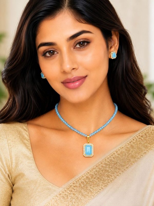Woman wearing sky blue pendant necklace set with matching stud earrings