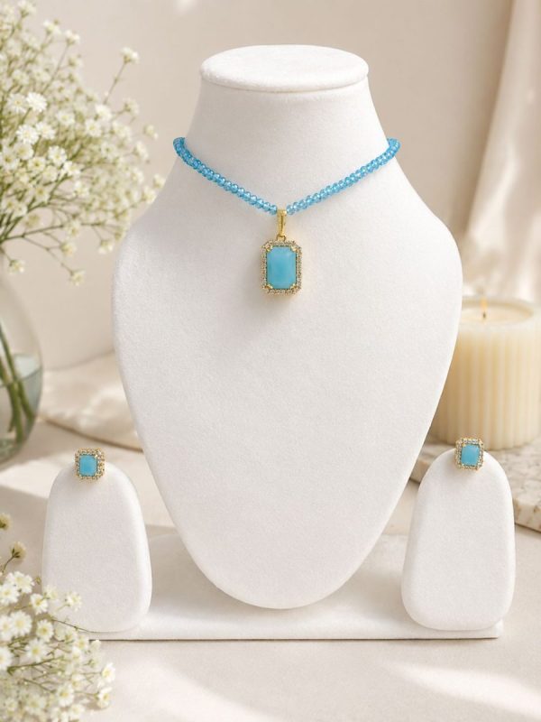 Sky blue pendant necklace set displayed on white jewellery stand