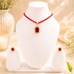 Red crystal pendant necklace set displayed on white jewellery stand