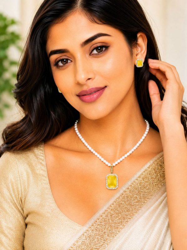 Woman wearing yellow crystal pearl pendant necklace set with matching stud earrings