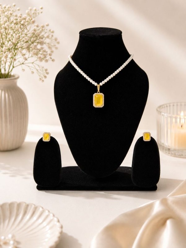 Yellow crystal pendant necklace set displayed on black jewellery stand