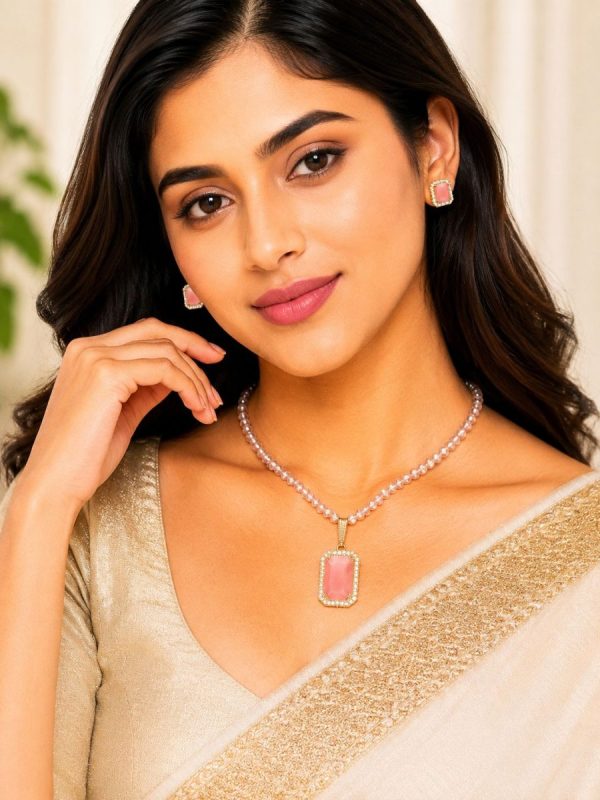 Woman wearing pink crystal pearl pendant necklace set with matching stud earrings