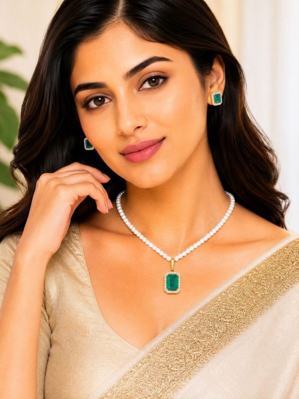 Woman wearing green crystal pearl pendant necklace set with matching stud earrings