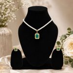 Green crystal pendant necklace set displayed on black jewellery stand