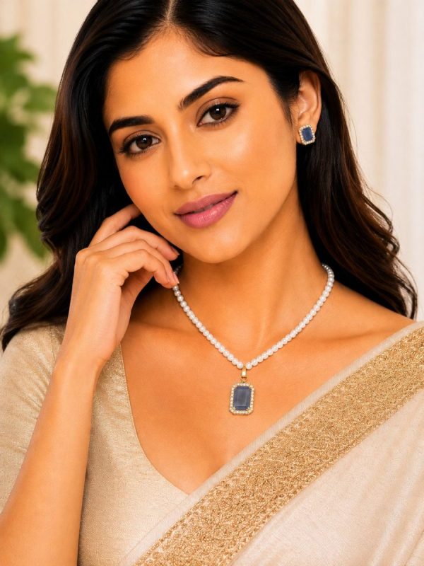 Woman wearing blue crystal pearl pendant necklace set with matching stud earrings