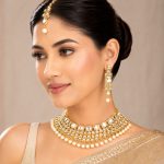 Side view of gold plated Kundan pearl choker necklace set with matching earrings