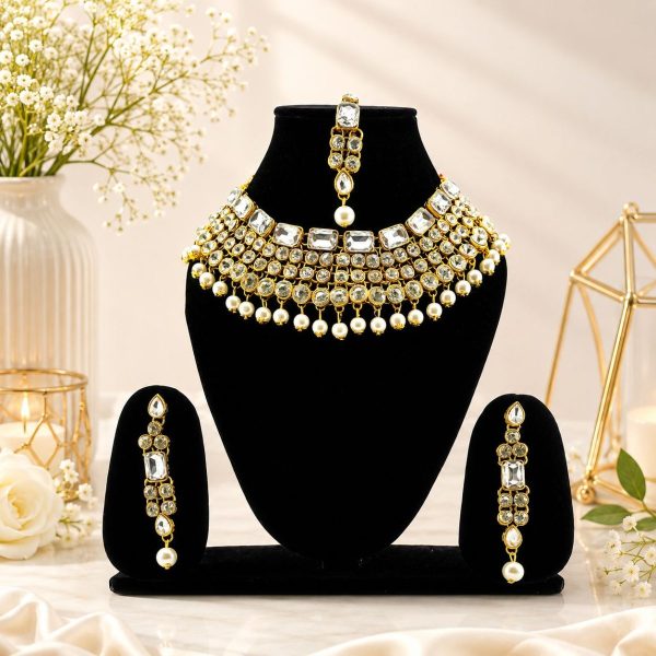 Gold plated Kundan pearl choker necklace set displayed on jewellery stand
