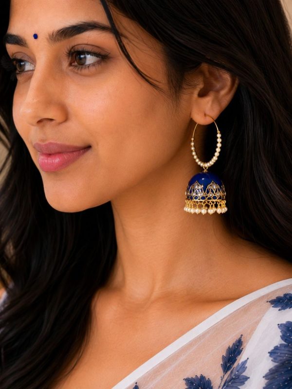 Woman wearing blue pearl hoop jhumka earrings with enamel and pearl design