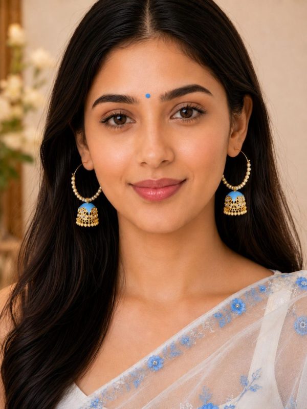 Woman wearing blue pearl jhumka hoop earrings with white floral saree