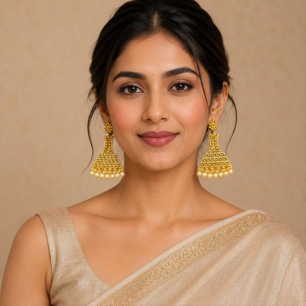 Woman wearing gold plated pearl drop jhumka earrings with ethnic saree
