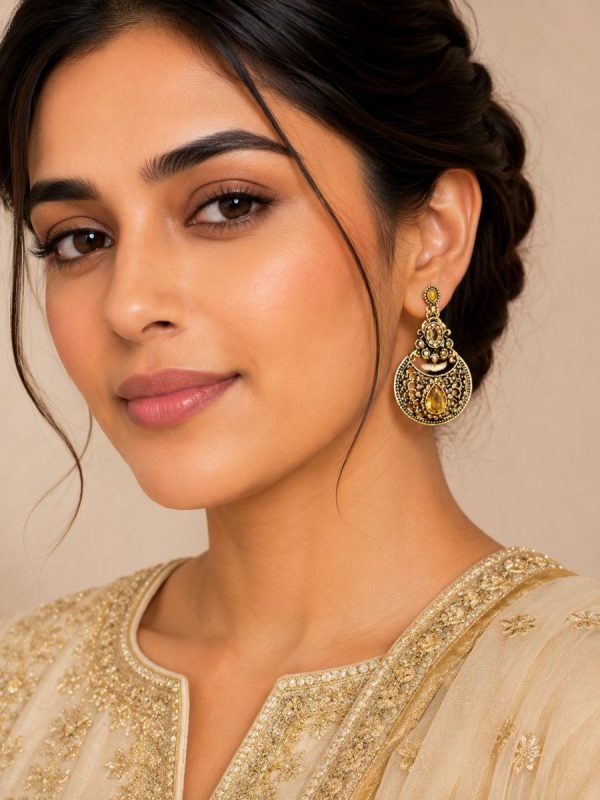 Woman wearing antique gold teardrop dangle earrings with ethnic outfit
