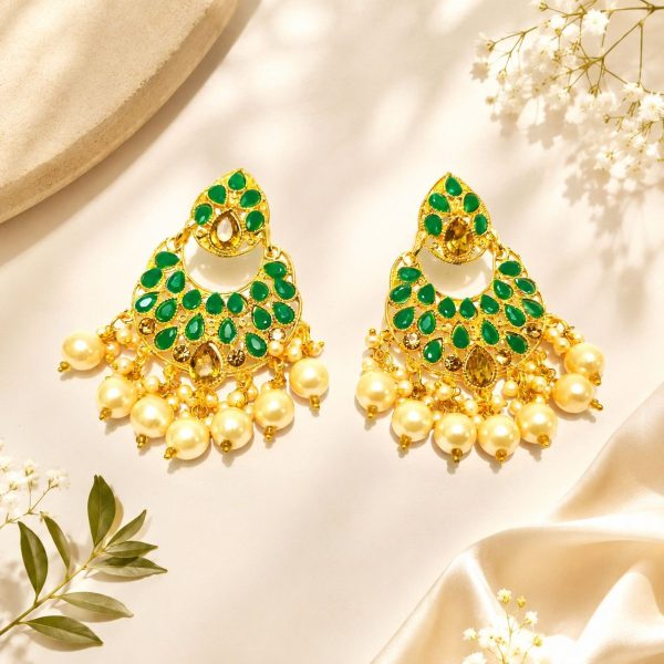 Gold plated green stone pearl chandbali earrings on decorative background